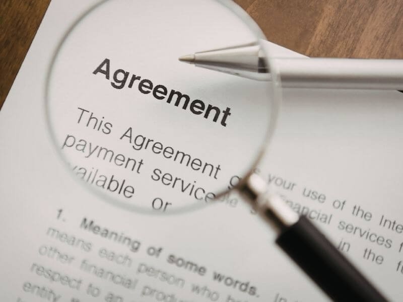 Lupa revisando documento: dónde encontrar la letra chica en la póliza Metalife Mujer de MetLife